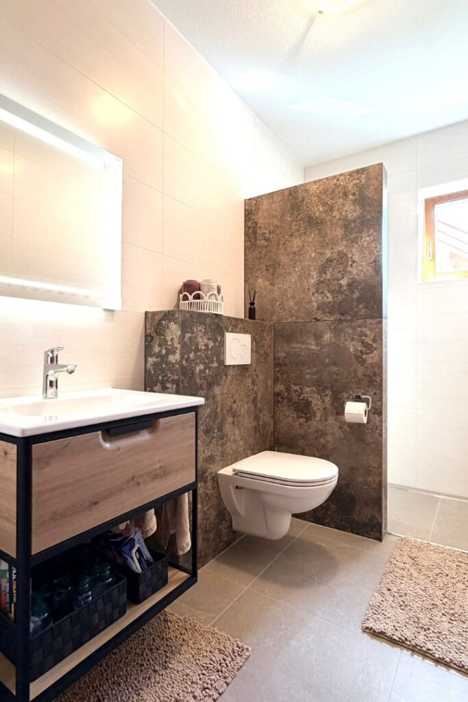 Modernes Badezimmer nach Badsanierung in Oberwart mit XXL-Fliesen und sauber ausgef&uuml;hrten Gehrungskanten