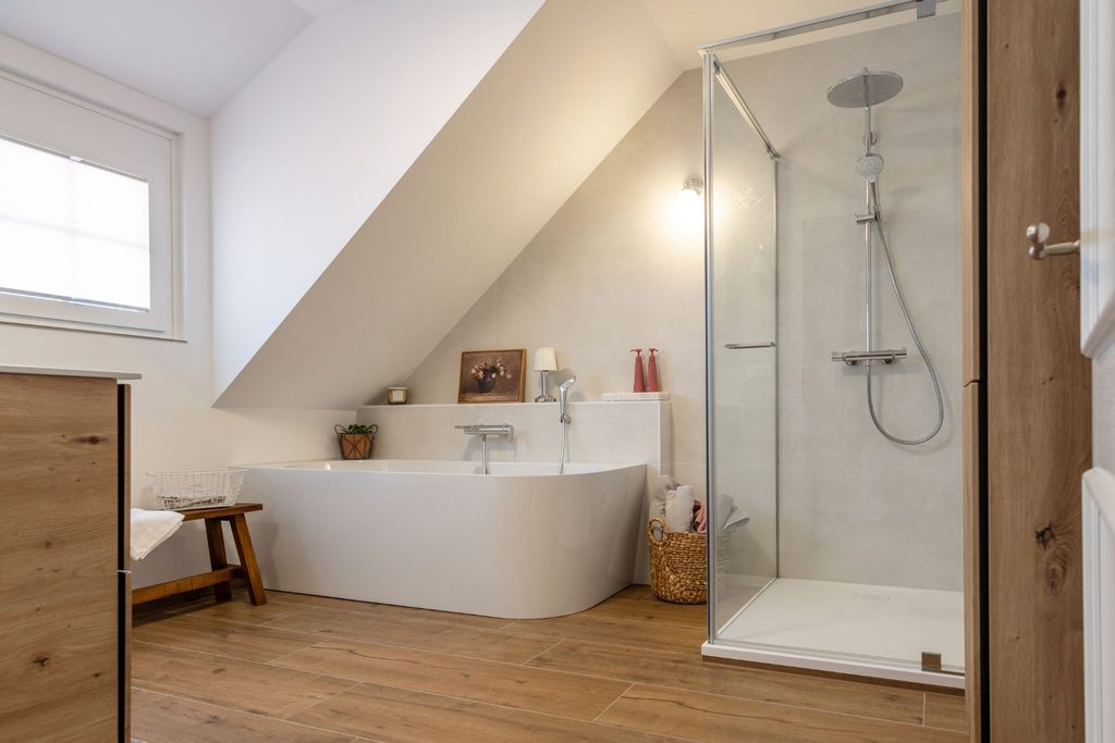 Modernisiertes Badezimmer im Landhausstil mit Badewanne, Dusche und Fliesen in Holzoptik